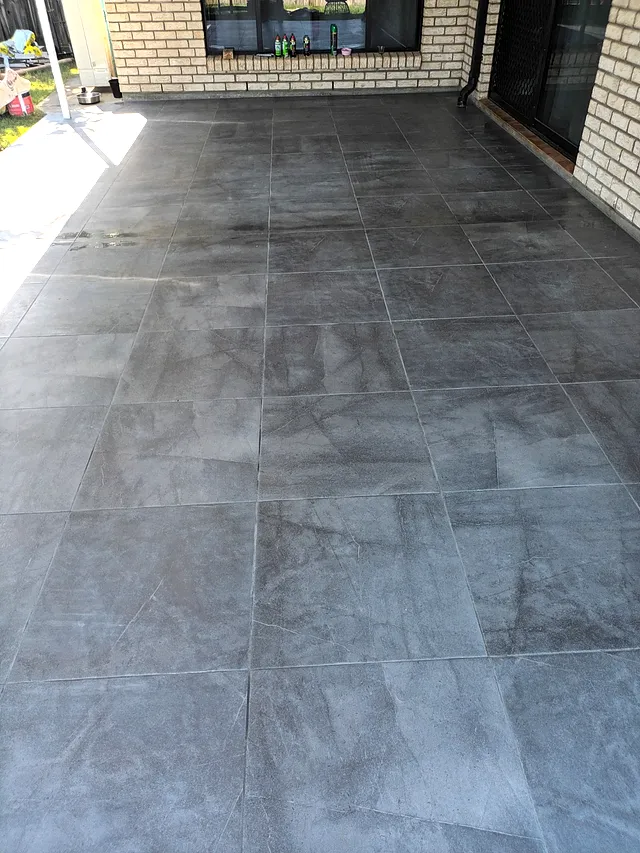Large-format dark tiles laid on an outdoor covered area