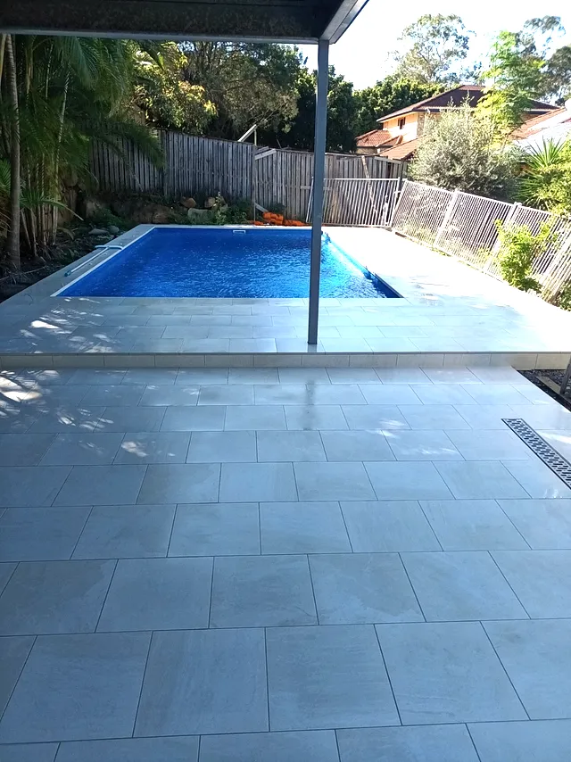 Pool surround with large-format tiles and a channel drain