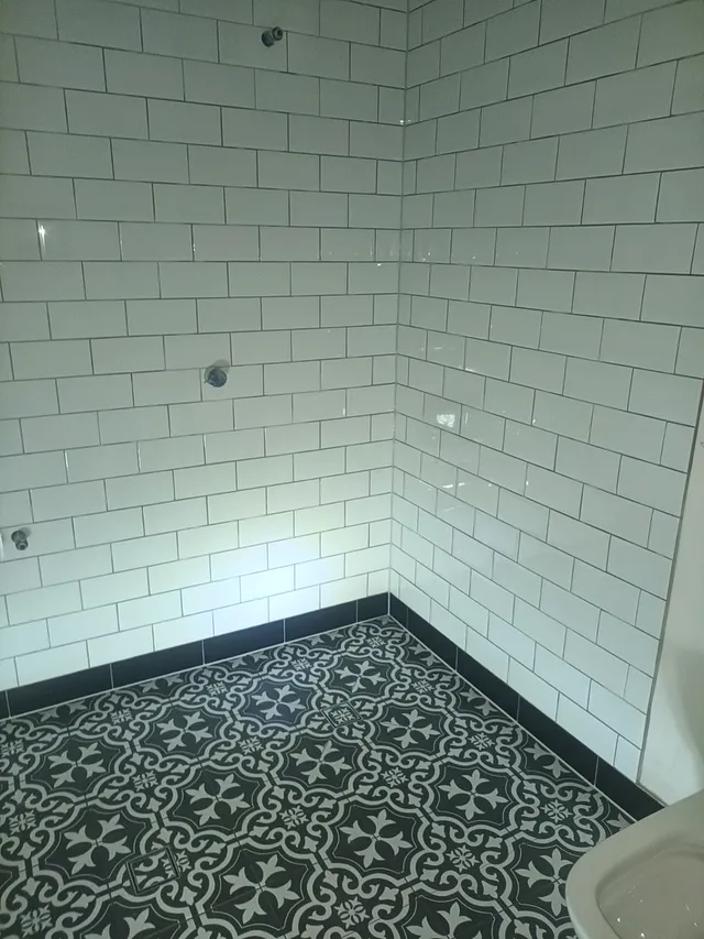 Bathroom with white subway wall tiles and a black-and-white patterned floor