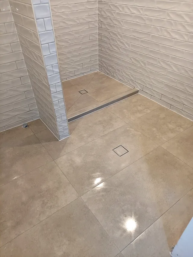 Shower recess with textured wave wall tiles and beige floor tiles