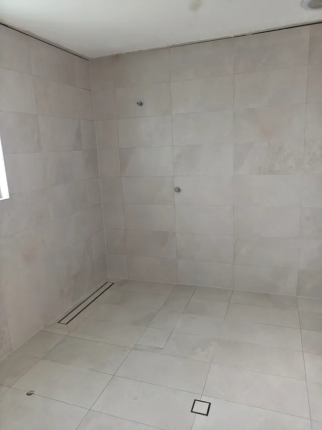 Light stone-look shower walls and floor with a square drain