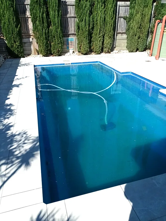 Blue pool with a tiled surround and coping