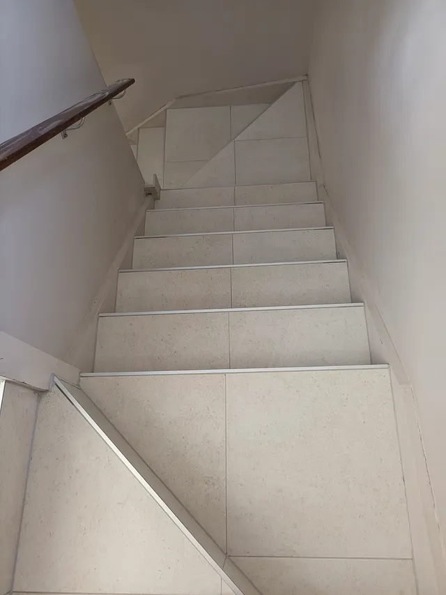 Staircase with tiled treads and risers and matching skirting