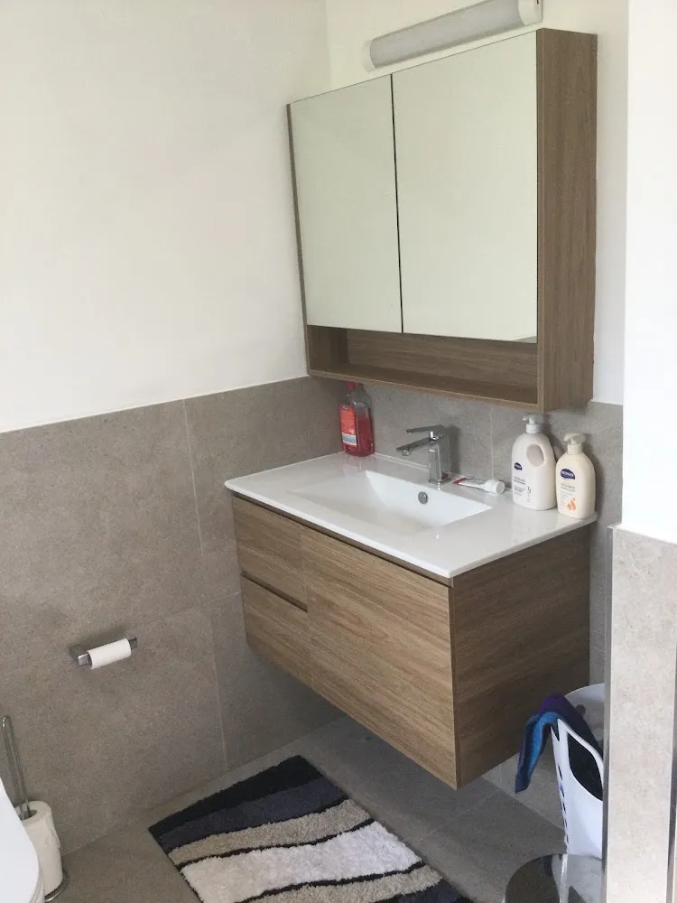 Bathroom with a floating timber vanity and stone-look wall tiles